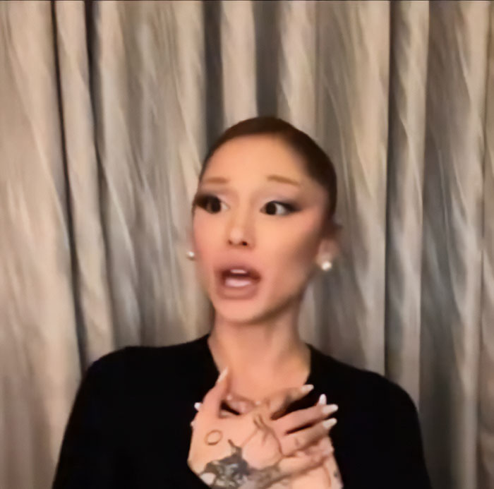 Ariana Grande with expressive hand gestures and unusual facial expressions in a recent interview sparking bizarre mannerisms theories.