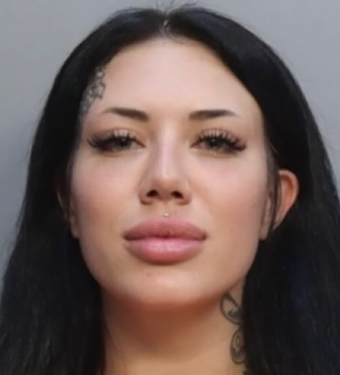 Young woman with long black hair and facial tattoos in a close-up mugshot, related to adult stars arrested incident.