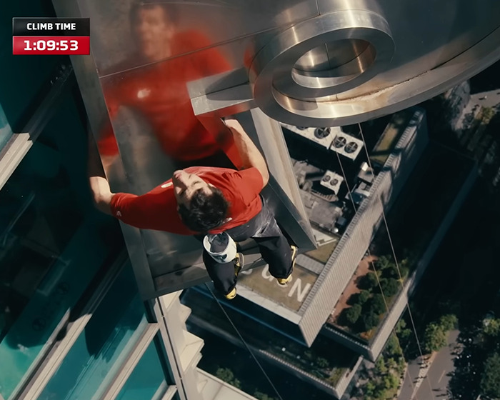 Climber scaling a 500-meter skyscraper with a timer visible, highlighting Netflix backlash over low pay disclosure.