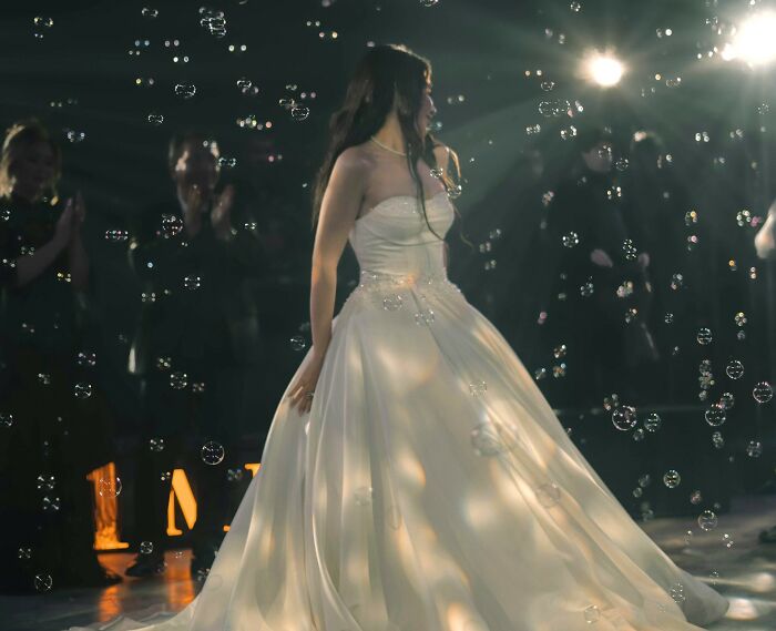 Bride in a white wedding dress surrounded by bubbles during a ceremony, capturing candid wedding moments and emotions.