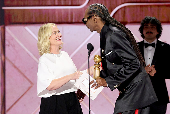 Two celebrities interacting on stage at an award show, highlighting strict rules celebrities follow during award events.