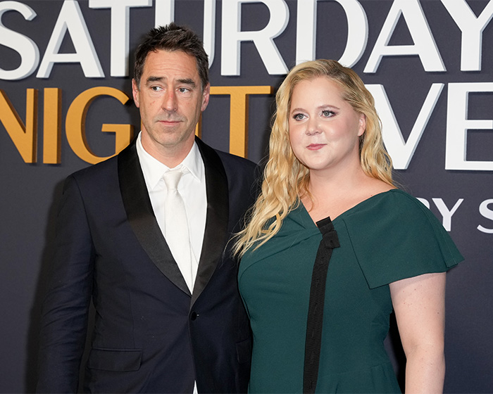 Amy Schumer and her husband at an event amid divorce filing and backlash over bikini photos.