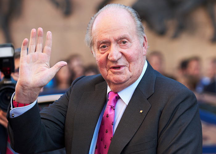 Elderly man in suit and pink tie waving, with blurred crowd in background regarding Prince Andrew move after eviction.