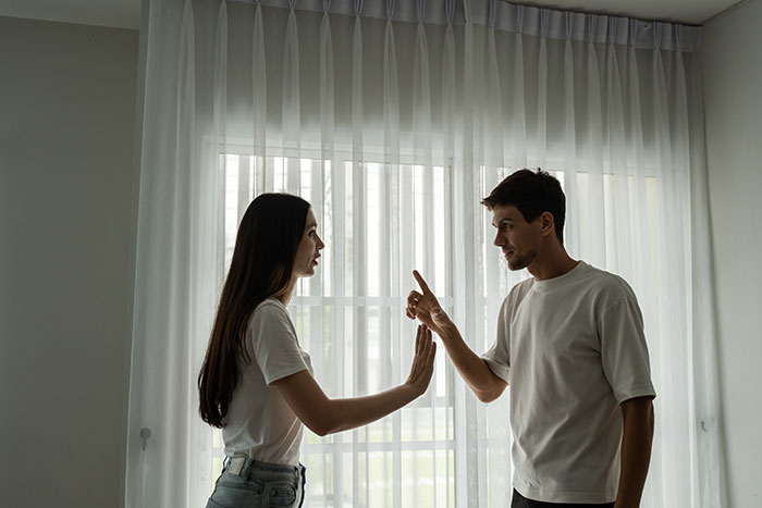 Young couple having a tense discussion indoors, highlighting landlord and profit sharing conflict in a modern setting. Young couple having a tense discussion indoors, highlighting landlord and profit sharing conflict in a modern setting.