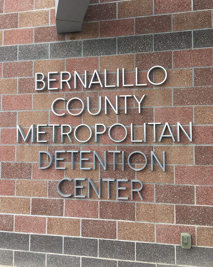 Bernalillo County Metropolitan Detention Center exterior wall with signage during armed federal agents operation.