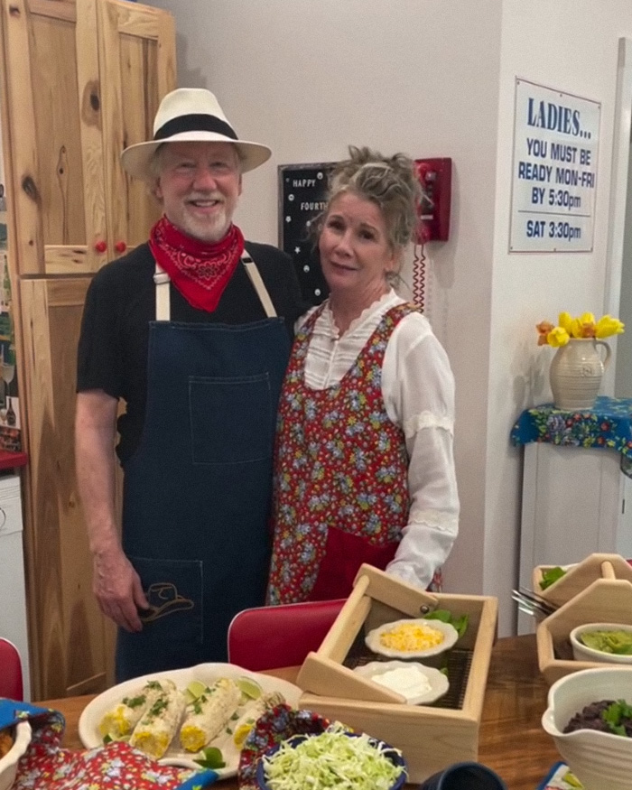 Couple in aprons standing in kitchen with food on table, unrelated to armed federal agents smashing down door keywords
