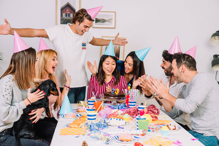 Family celebrating a birthday with party hats, a cake, and a camera capturing moments with an aunt present. Family celebrating a birthday with party hats, a cake, and a camera capturing moments with an aunt present.