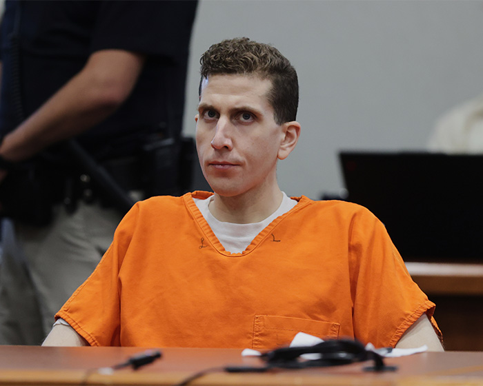 Bryan Kohberger in an orange prison jumpsuit seated in courtroom during hearing related to disturbing victim autopsy details. Bryan Kohberger in an orange prison jumpsuit seated in courtroom during hearing related to disturbing victim autopsy details.