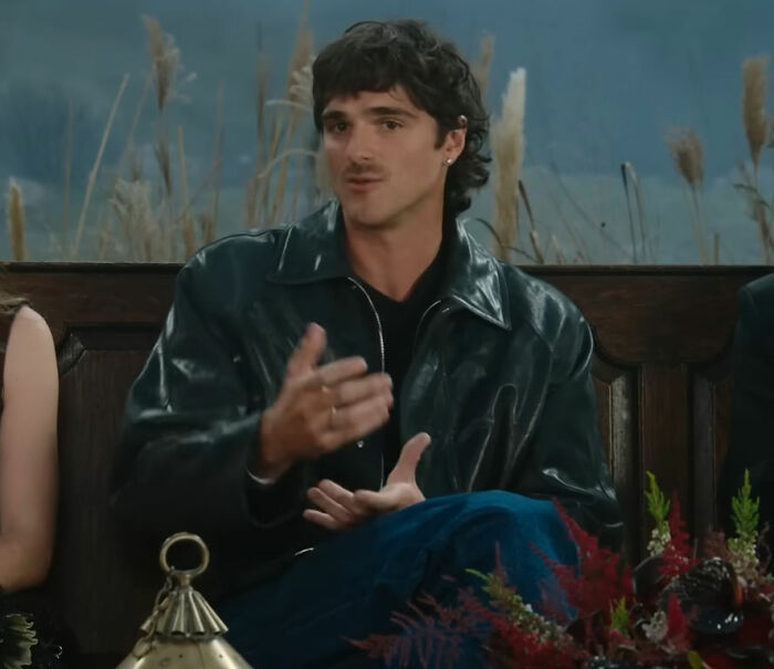 Jacob Elordi wearing a black leather jacket while speaking on set, linked to Margot Robbie Wuthering Heights rumors.