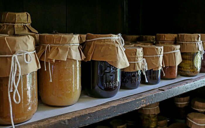 Jars of preserved food lined up on a rustic shelf, symbolizing thoughtful dating gestures and meaningful care.