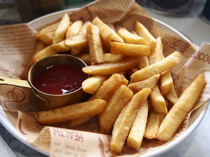 Basket of golden French fries with ketchup serving, highlighting simple yet satisfying dating gestures and choices.