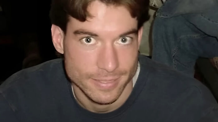 Young man with light brown hair and blue eyes smiling slightly, related to biggest unsolved cases from around the world.