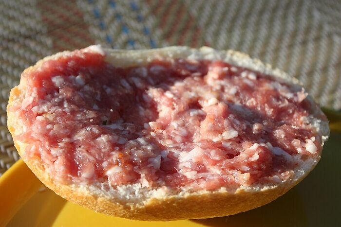 Raw minced pork spread thick on a bread roll, an example of disgusting local delicacies from around the world.