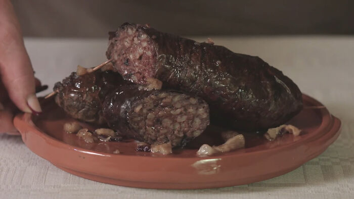 Blood sausage on a clay plate showcasing one of the disgusting local delicacies from various countries around the world.