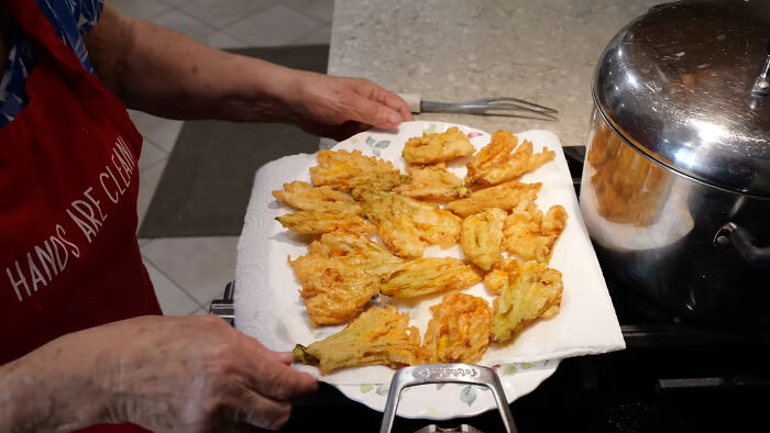 Person holding a plate of fried local delicacies, showcasing unusual and controversial food from various countries.
