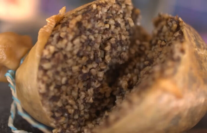 Close-up of a sliced local delicacy showing coarse grain and meat texture, highlighting unusual food choices.