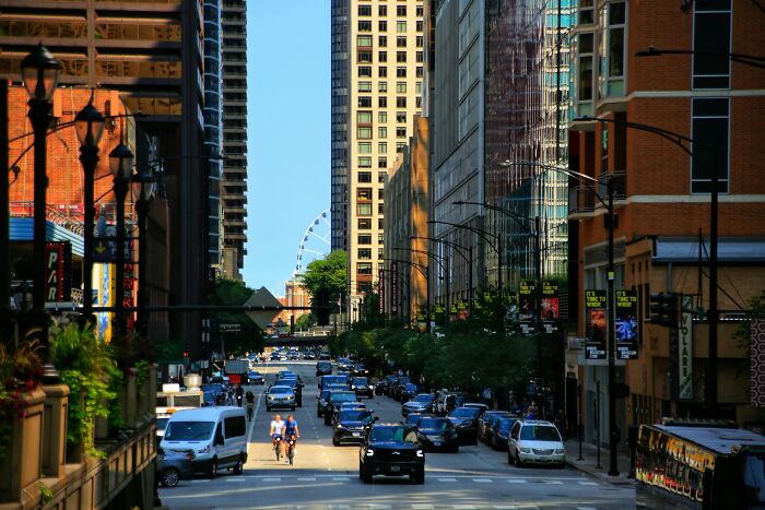 Busy city street with cars and cyclists during the day, illustrating urban living safety tips for women living alone.