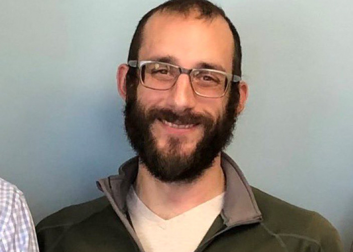 Alex Pretti smiling with glasses and a beard against a plain background before his fatal encounter. Alex Pretti smiling with glasses and a beard against a plain background before his fatal encounter.