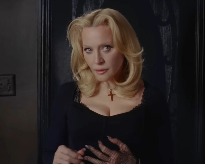 Madonna in a raunchy Dolce & Gabbana ad, posing with younger men and a bold c****h shot scene.