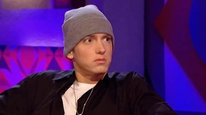 Eminem wearing a gray beanie and black jacket, representing celebs who weren’t nepo babies and changed their lives.