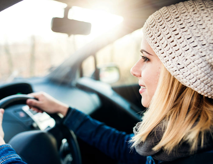 Young woman driving a car, showing refusal to drive her ungrateful brother who trashed her girly car.