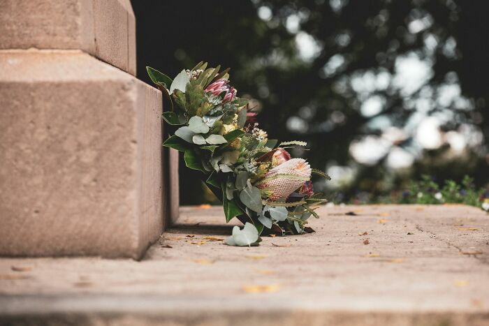 Bouquet of flowers on stone steps at a memorial, a somber scene for hospital workers