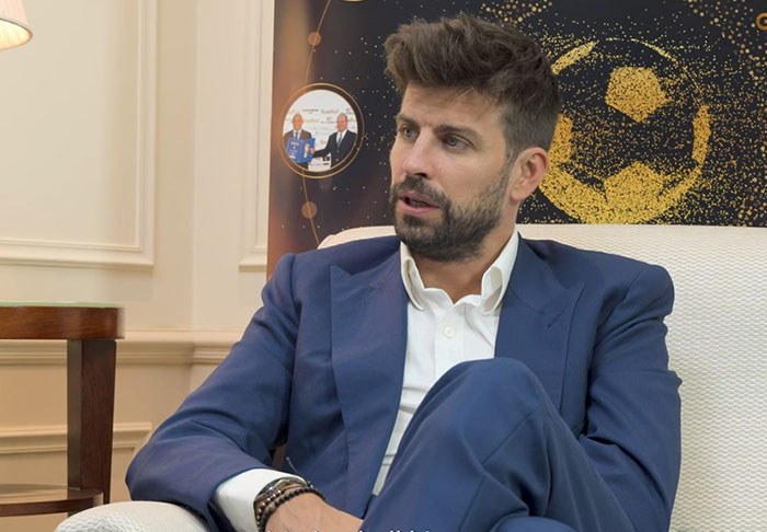 Man in a blue suit sitting in an armchair, appearing thoughtful, related to celebrity infidelity scandals topic.