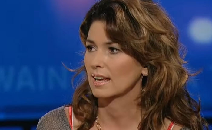Woman with brown hair speaking in a television interview about celebrity infidelity scandals and controversies.
