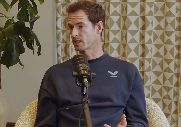 Man in a navy sweatshirt speaking into a microphone during an interview featuring savage responses to annoying questions.