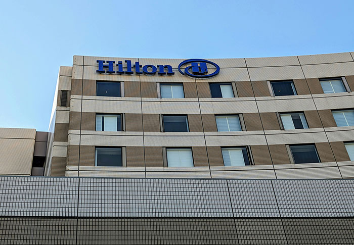 Hilton hotel building facade under clear sky, representing celebrities out of touch with reality concept.