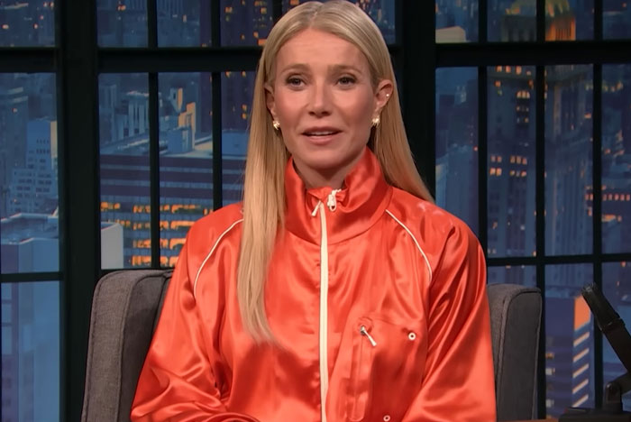 Celebrity in an orange jacket speaking on a late-night talk show, showcasing moments out of touch with reality.