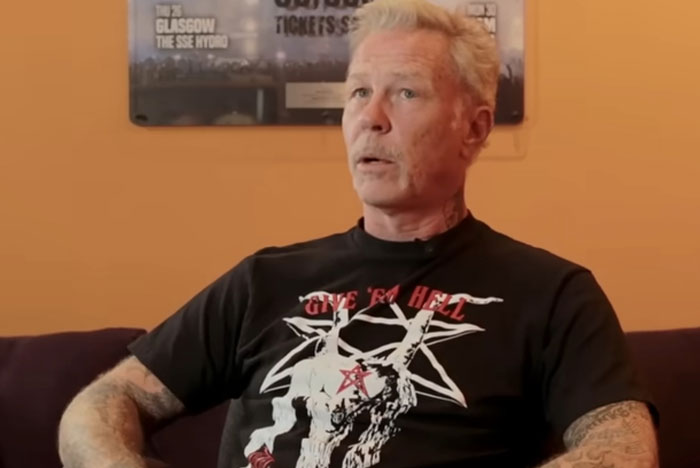 Middle-aged man with tattoos wearing a graphic shirt, looking surprised in a setting showing celebrities out of touch with reality