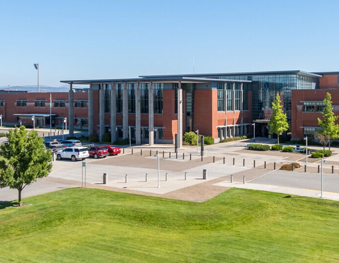 Modern school building exterior with cars parked outside, related to bold texts from teacher to student discussions. Modern school building exterior with cars parked outside, related to bold texts from teacher to student discussions.