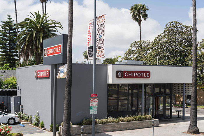 Chipotle restaurant exterior with palm trees in a sunny setting, related to billionaires and Bill Ackman donation controversy.
