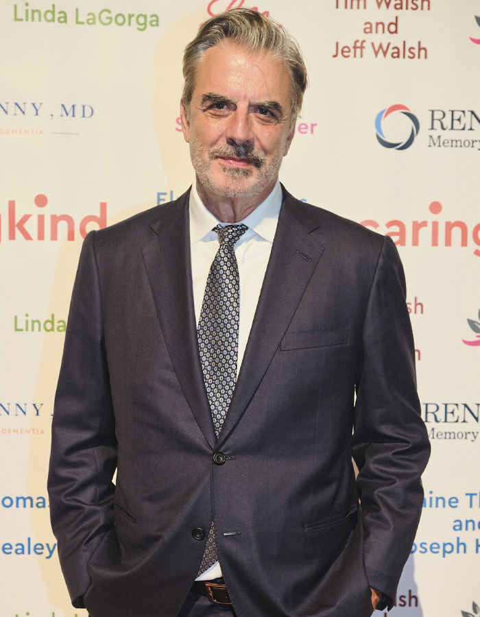 Chris Noth in a dark suit at a formal event amid background text related to Sarah Jessica Parker feud discussion.