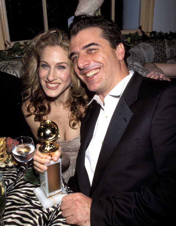 Sarah Jessica Parker and Chris Noth smiling at an event, highlighting their feud and award controversy.