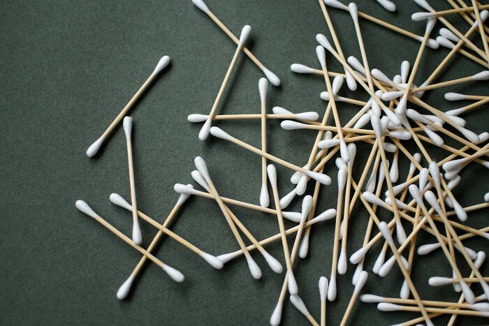Scattered cotton swabs on a dark surface illustrating common daily dangers you might not realize exposing yourself to.