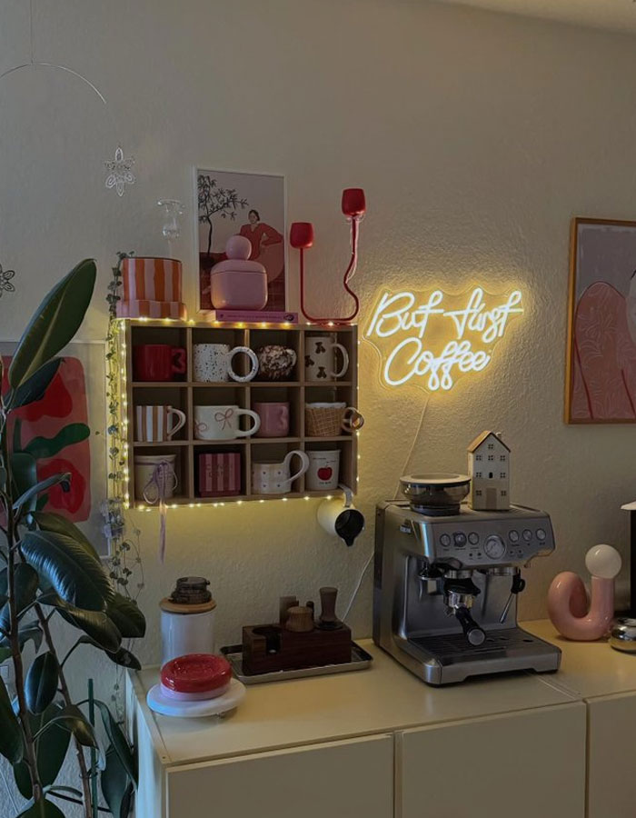 Cozy kitchen corner with coffee machine, decorative mugs, neon sign, and plants showcasing cool interior design ideas.