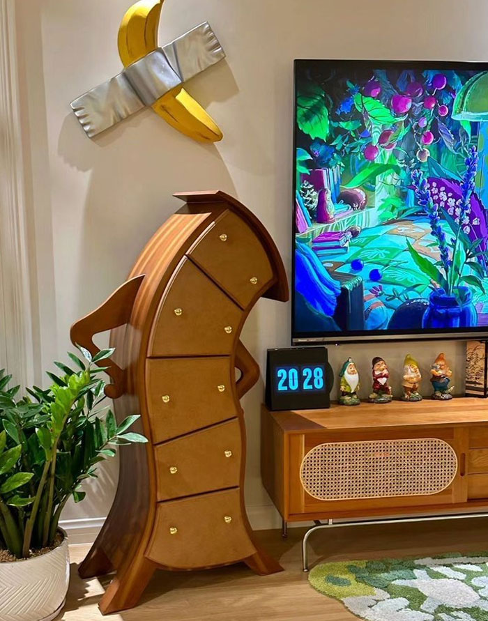 Mueble con diseño original y moderno en sala decorada con plantas y colorido cuadro, inspiración para diseño interior.