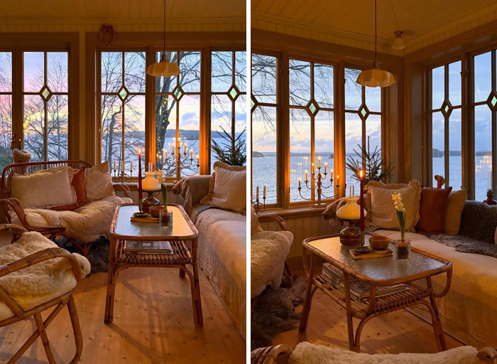 Sala acogedora con diseño interior cálido, muebles de madera y grandes ventanas con vista al lago al atardecer.