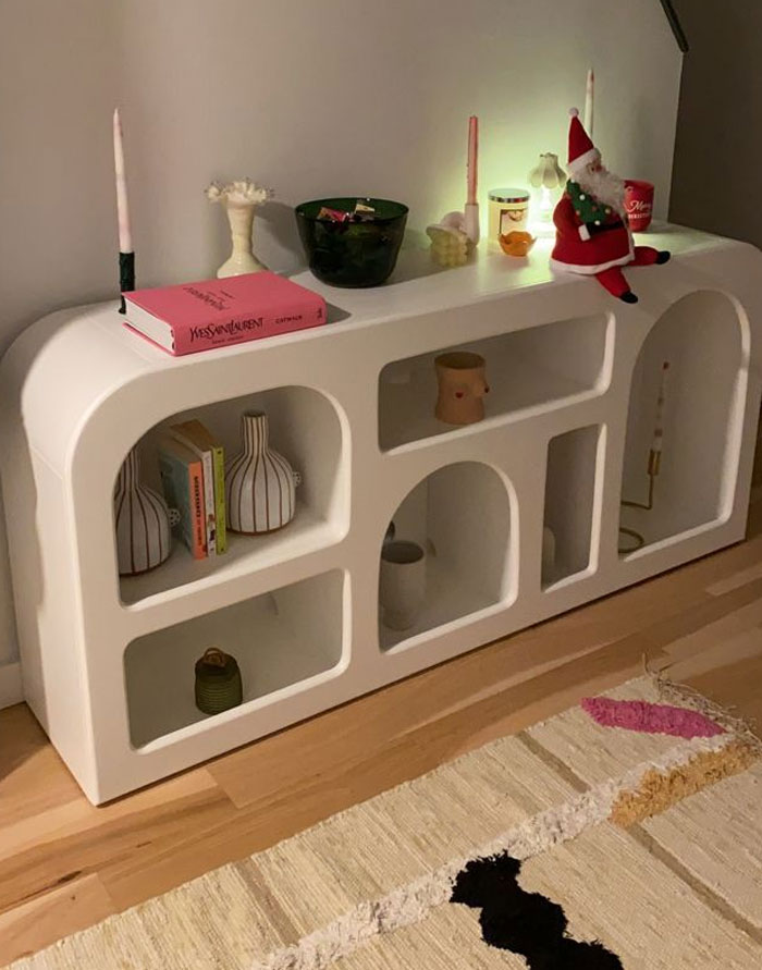 Minimalist white shelving unit with vases, candles, and decorative items showcasing cool interior design ideas.