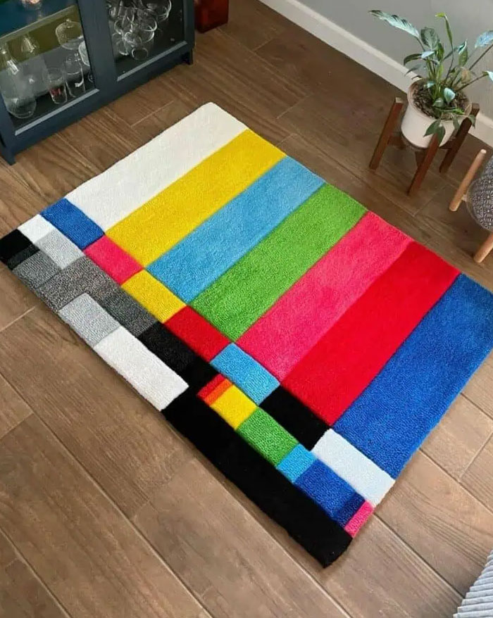 Alfombra de diseño interior con patrón colorido y moderno sobre piso de madera, ideas frescas para renovar el hogar.