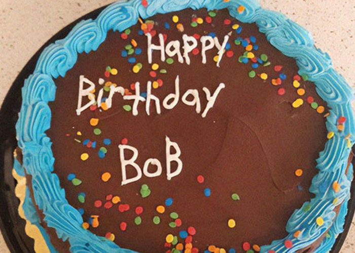 Chocolate birthday cake with blue frosting and colorful sprinkles celebrating a fun couples' house rules joke.