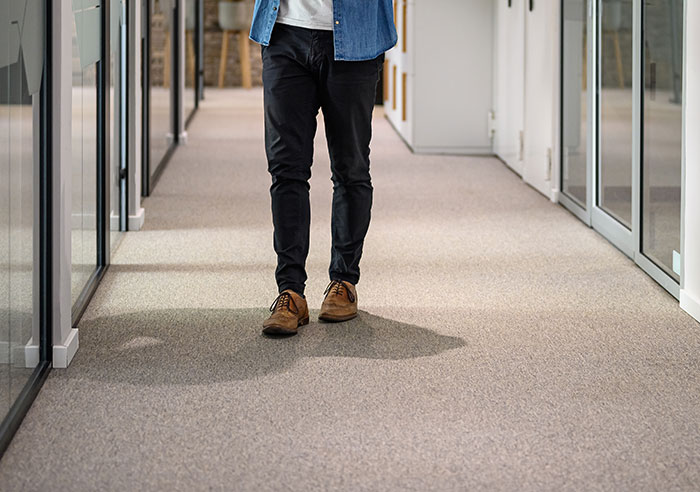 Person walking down office corridor, illustrating intelligence so sharp it made me feel like my brain was spaghetti.
