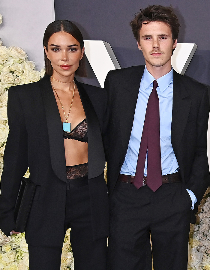 Cruz Beckham with girlfriend in black outfits at event, sparking buzz about mom lookalike and age questions.