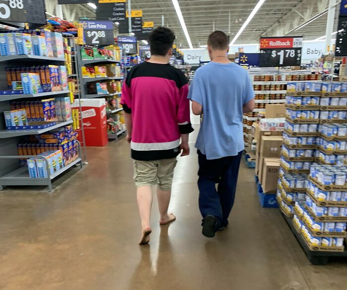 Two people walking barefoot in a grocery store aisle, illustrating things normal in their country but offensive elsewhere.