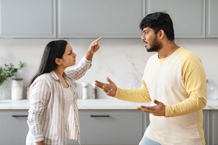Young man and woman having a heated argument in the kitchen, dad and brother cooking food scene without actual cooking shown.