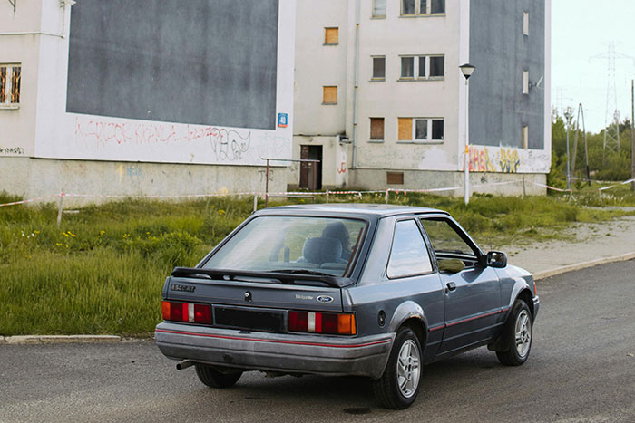 Old car parked near abandoned buildings, illustrating one of the most dangerous things people willingly or unwillingly did.