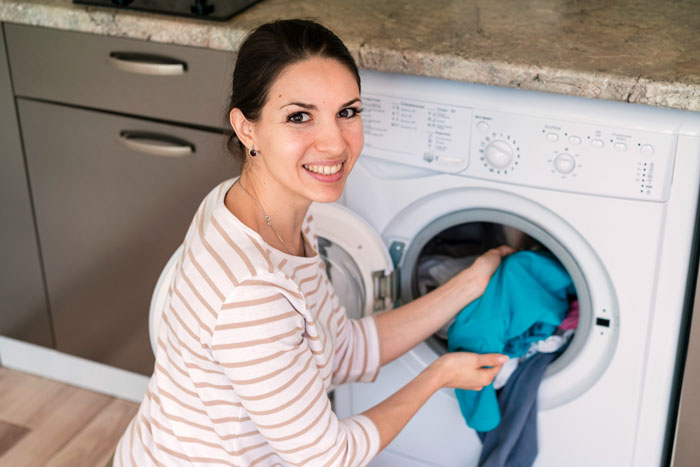 Woman doing laundry at home, illustrating chores related to annoyed mom and teen daughter conflict themes.