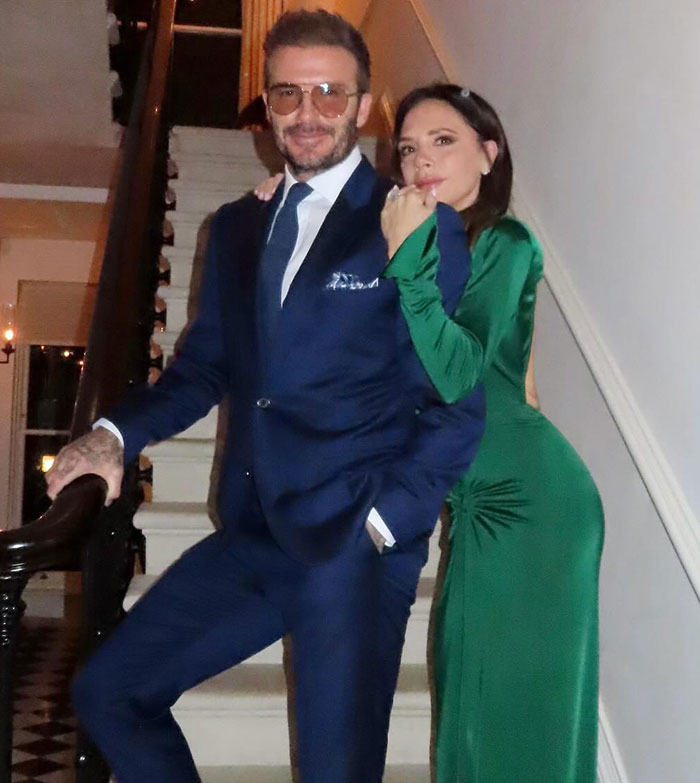 Brooklyn Beckham posing with a woman on stairs, linked arms, amid family feud and social media posts controversy.